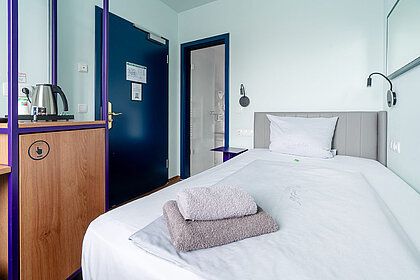 Economy Einzelzimmer im Hotel Schreder München – gemütliches Bett und stilvolle Einrichtung für eine günstige Übernachtung