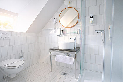 helles Bad im preiswerten 4-Bett Familienzimmer in München  bequemer Lounge-Chair im preiswerten 4-Bett Familienzimmer in München  großzügiges, helles Bad - preiswerte Classic Gruppen-/Familienzimmer in München