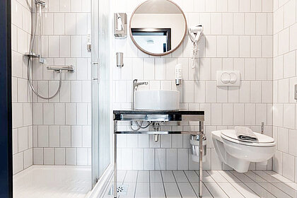 helles Bad im preiswerten 4-Bett Familienzimmer in München  bequemer Lounge-Chair im preiswerten 4-Bett Familienzimmer in München  großzügiges, helles Bad - preiswerte Classic Gruppen-/Familienzimmer in München